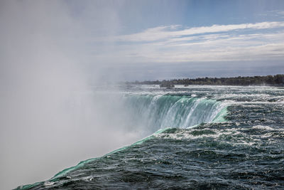 Scenic view of waterfall against sky