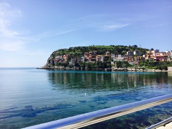 Townscape by sea against sky in town