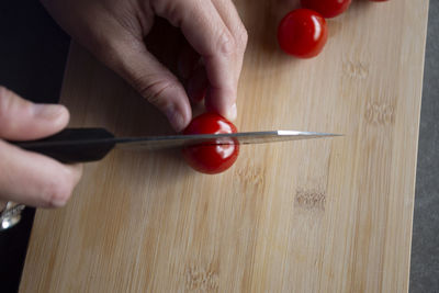 Close up view of someone cutting tomatoes with a chefs knife