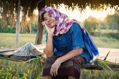 Senior farmer sitting on field