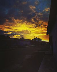 View of houses against cloudy sky during sunset