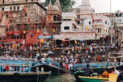 People on boats in canal along buildings