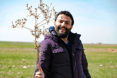 Portrait of young man standing on field