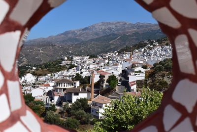 Aerial view of townscape and mountains against sky