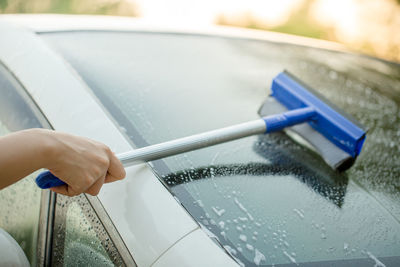 Cropped hand of person cleaning car