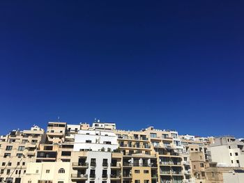 Residential buildings against clear blue sky