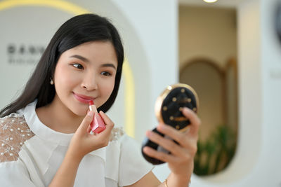 Portrait of young woman holding christmas decoration