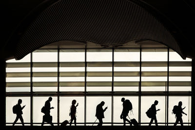 Silhouette people walking in modern building