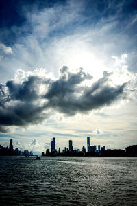 Sea by buildings against sky in city