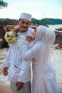 Midsection of couple standing against clear sky