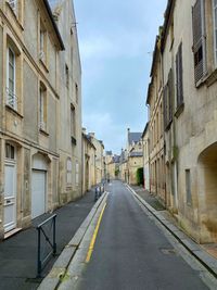 Empty road amidst buildings in city