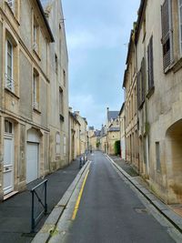 Empty road amidst buildings in city