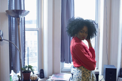 A young woman posing by windows