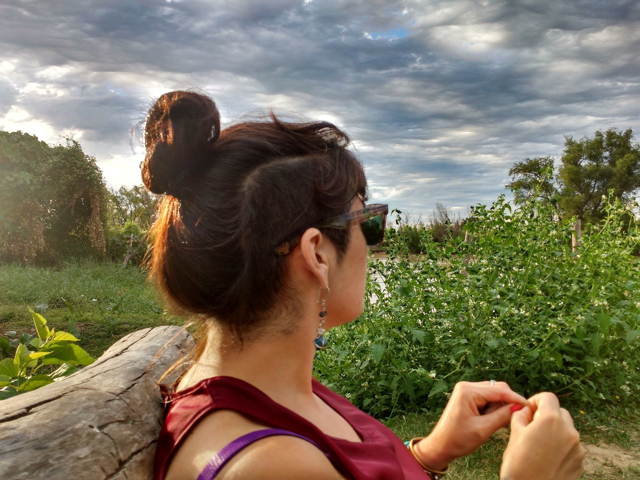 CLOSE-UP OF WOMAN LOOKING AWAY AGAINST TREES