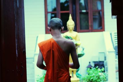 Rear view of a young monk in temple