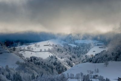 Snow covered landscape against sky