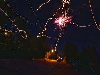 Low angle view of fireworks against sky at night