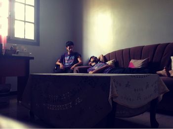 Rear view of woman sitting on sofa