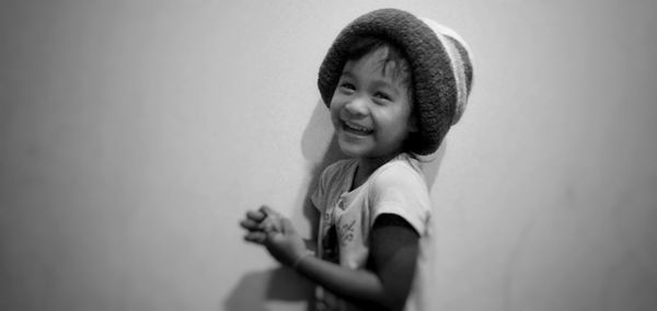 Portrait of smiling girl against wall