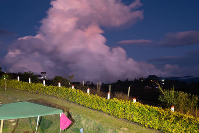 Panoramic shot of illuminated field against sky at sunset