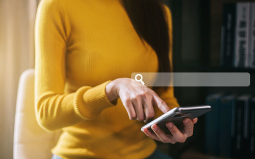 Midsection of woman using mobile phone