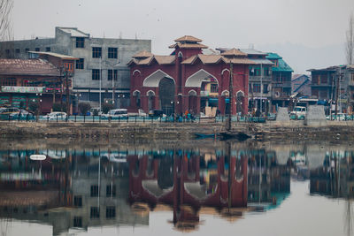 Reflection of buildings in lake against sky