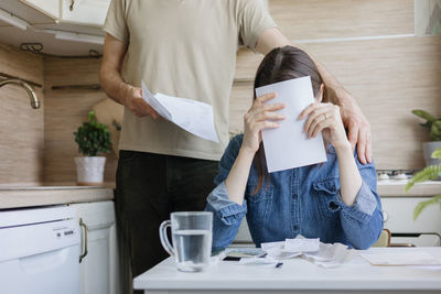 Midsection of woman using mobile phone while sitting on table