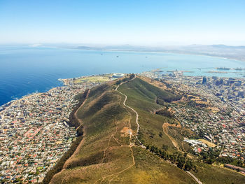 Aerial view of townscape by sea against sky