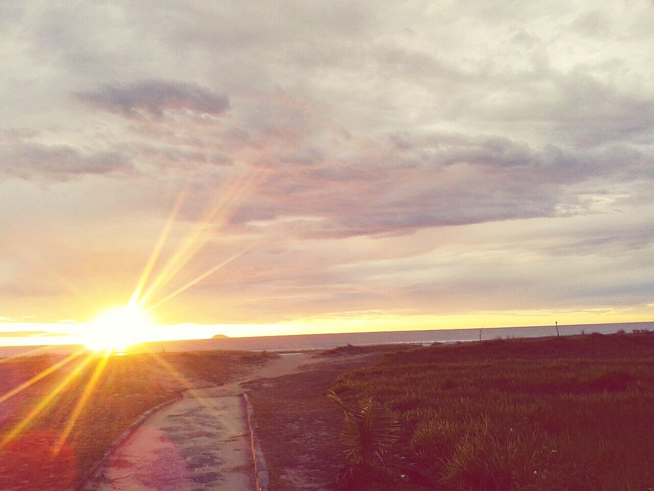 sunset, sun, sky, sunbeam, cloud - sky, scenics, tranquil scene, tranquility, beauty in nature, landscape, sunlight, nature, orange color, lens flare, cloudy, idyllic, cloud, field, non-urban scene, horizon over land