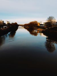 Reflection of buildings in river against sky