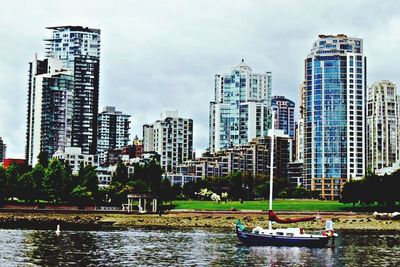 Boats in river with city in background