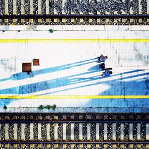 Directly above shot of friends standing on railroad station platform