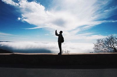 Silhouette of woman against cloudy sky