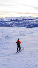 Rear view of person skiing on snow covered mountain