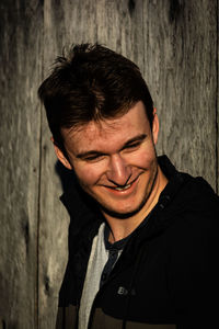 Portrait of smiling young man against wall