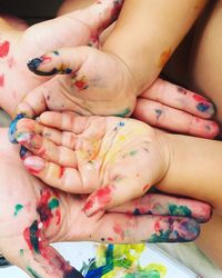 High angle view of messy painted hands