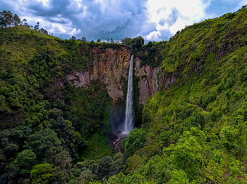 Scenic view of waterfall against sky