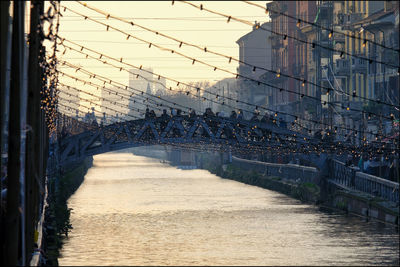 Bridge over river against sky during sunset