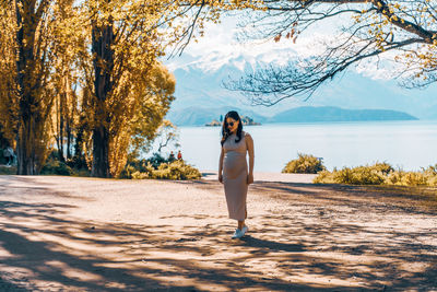 Full length of young woman standing on shore