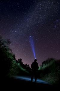 Silhouette person standing on field against sky at night