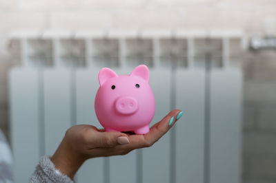 Close up of hand holding piggybank