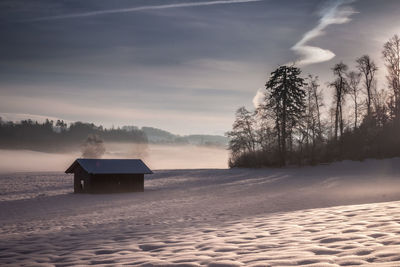 Scenic view of snow covered land against sky