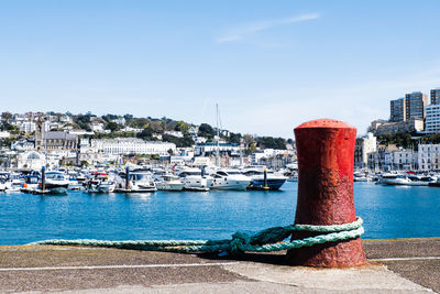 Sailboats moored in harbor