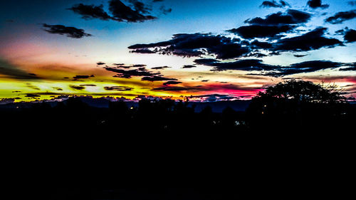 Scenic view of dramatic sky over silhouette landscape