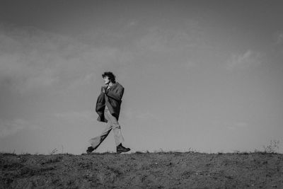 Man standing on field against sky