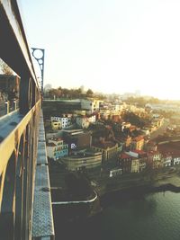 Bridge over river in city against clear sky