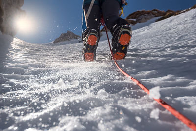 Low section of person skiing on snowcapped mountain