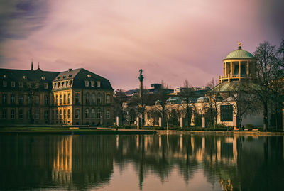 Reflection of buildings in city at sunset