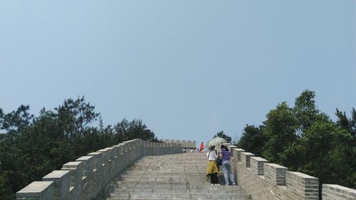 Tourists standing on great wall of china against sky
