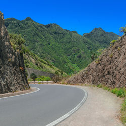 Road amidst mountains against clear sky